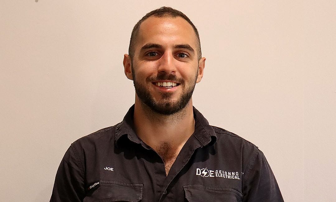 Joe, founder of Deionno Electrical and Solar, in a branded work shirt